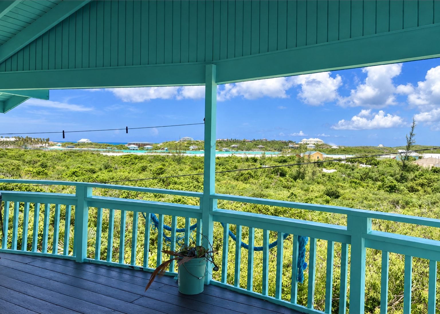 Teal railed deck view over the dune grass toward the water