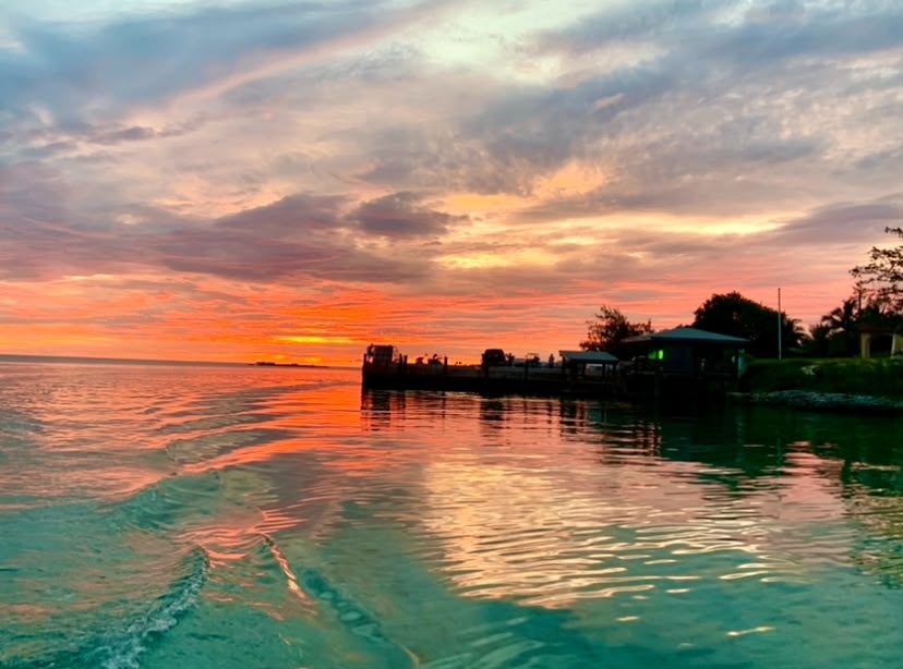Colorful sunset over the water beside a dock