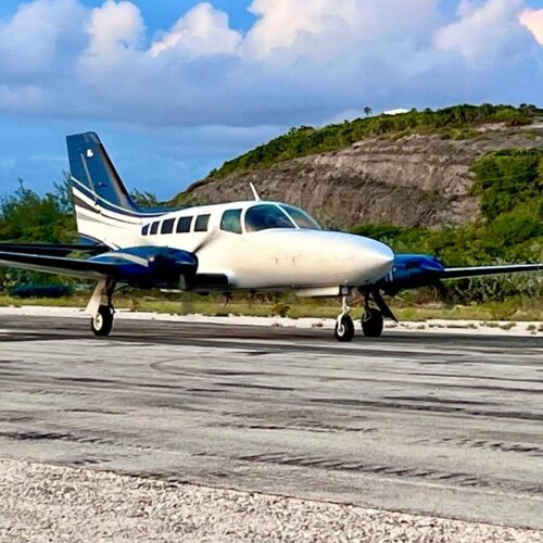 Graceful Wings twin engine aircraft parked on the airstrip under a blue sky
