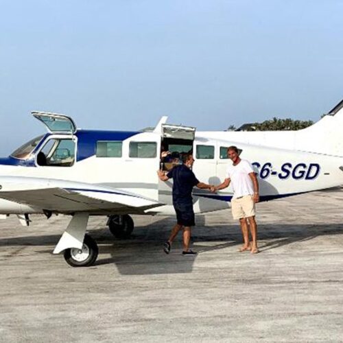 Passengers greeting the pilot beside a charter plane
