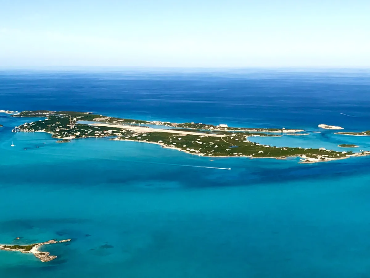 Aerial view of a cay ringed by turquoise water in the Exumas